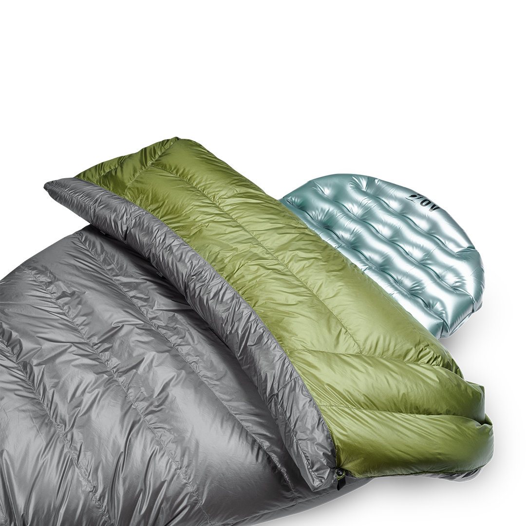 Close-up view of the Outdoor Vitals StormLoft Down TopQuilt pulled down to reveal its soft inner lining, paired with an inflatable sleeping pad setup.