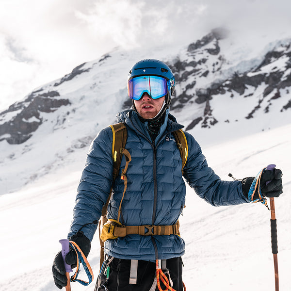 A mountaineer in a NovaPro down jacket and climbing gear on a snowy mountain.