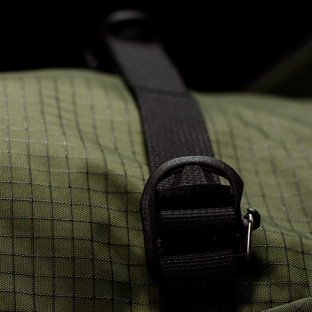 Close-up of a textured bag with a black strap and buckle.