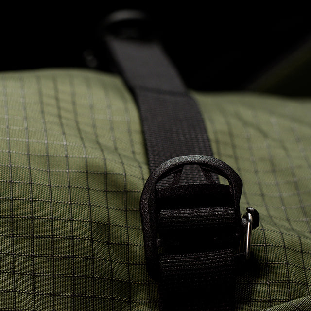Close-up of a textured bag with a black strap and buckle.