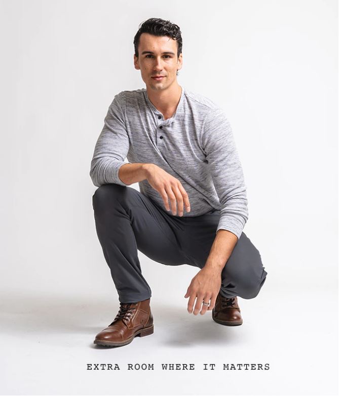 Model crouching to show the fit of Outdoor Vitals Satu Adventure Pants.