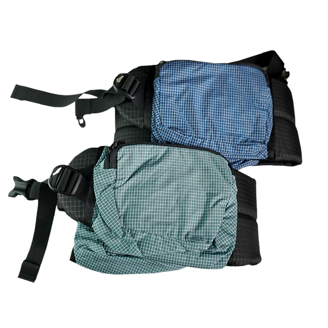 Product shot showing the detachable hip belt pockets of the Outdoor Vitals Shadowlight Carbon 60 Backpack, featuring durable ripstop grid fabric and zippered closures.