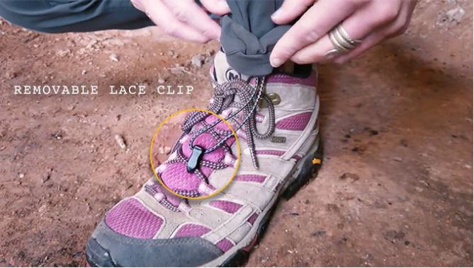 Close-up of the bottom hem of Outdoor Vitals Satu Adventure Pants, highlighting the removable lace clip feature secured to a hiking boot's laces.