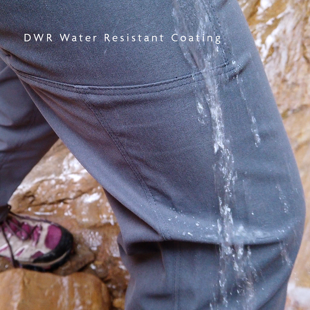 Extreme close-up of water splashing and sliding off Outdoor Vitals Satu Adventure Pants, illustrating the DWR water-resistant coating.