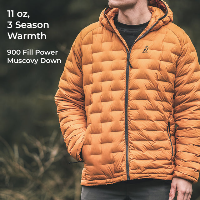 A man wearing a puffer jacket outdoors, with text on the left reading '11 oz, 3 Season Warmth' and '900 Fill Power Muscovy Down'.