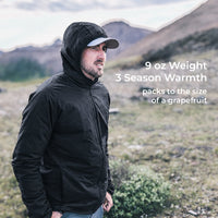 A man wearing a black hooded lightweight jacket stands outdoors in a mountainous grassy landscape. White text on the right reads '9 oz Weight 3 Season Warmth packs to the size of a grapefruit.
