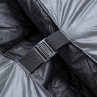 Close-up of a buckle and strap securing two sides of a backpacking quilt with a black interior together.