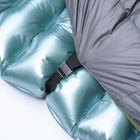 Close-up of the pad attachment strap and buckle securing the Outdoor Vitals StormLoft Down TopQuilt to an inflatable sleeping pad.