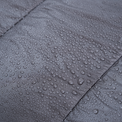 Close-up of water droplets beading on the surface of a quilt fabric, showing its water-resistant properties.