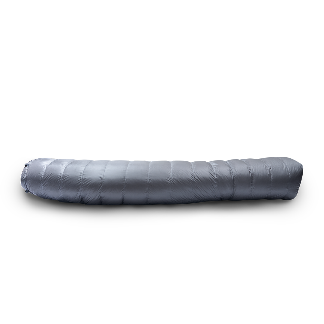 Side profile view of a backpacking quilt fully closed, showing its insulated baffles and tapered shape.