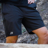 A close-up of a person wearing Outdoor Vitals Skyline Trail Shorts on an outdoor trail.