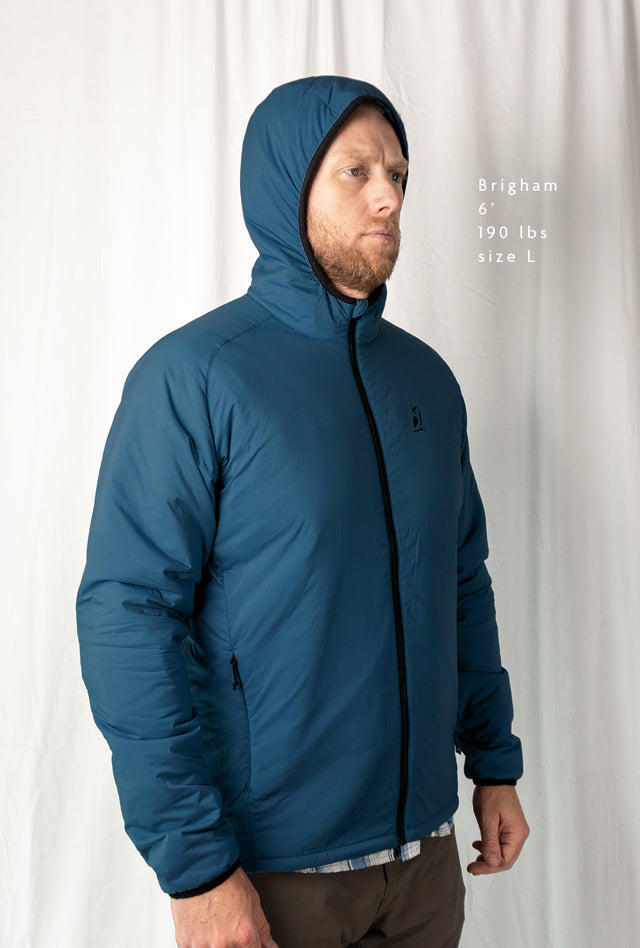 Man wearing the Outdoor Vitals Vario Jacket with the hood up, front angled view