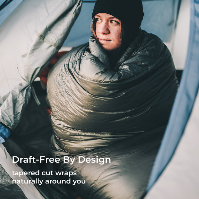 green 0 degree quilt wrapped around woman inside tent