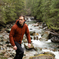 Hiker wearing the Outdoor Vitals Vario Jacket with a rocky mountain river in the background