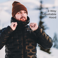 A man wearing a black puffer jacket and a brown knit beanie stands outdoors in a snowy setting, adjusting the collar of the jacket. The text '2-Way Adjustable Hood' appears on the right side.