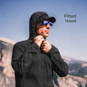 close view of man wearing dark hooded mid layer jacket on mountain peak