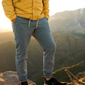 A person wearing Outdoor Vitals Skyline Trail Joggers on a mountain summit at sunset.