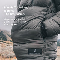 man stands with hands in kangaroo pocket of puffy down anorak jacket