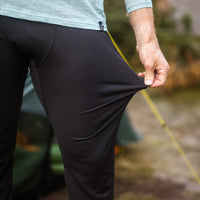 Hiker stretching the fabric of Outdoor Vitals Highline Thermal Leggings to show elasticity.
