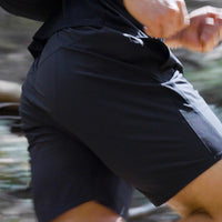 A person running on a trail wearing Outdoor Vitals Skyline Trail Shorts.