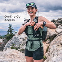 Hiker paused to get something out of running vest style pack harness. Text on screen says, "On-The-Go Access."