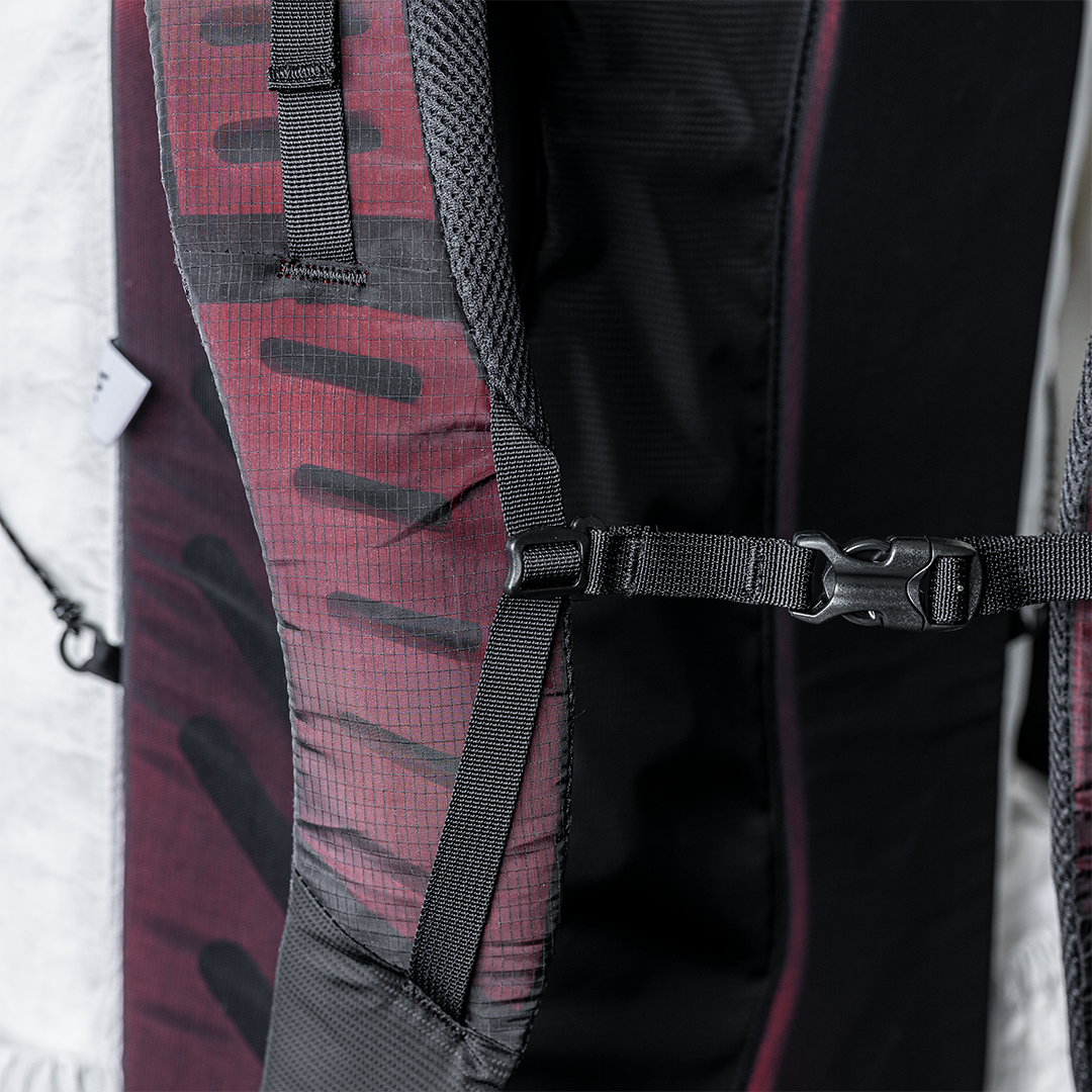 Close-up view of the Outdoor Vitals CS40 Ultra Backpack padded shoulder strap, highlighting the adjustable sternum strap buckle and webbing attachment loops.