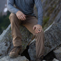 Hiker resting on rocks wearing Outdoor Vitals Satu Adventure Pants.