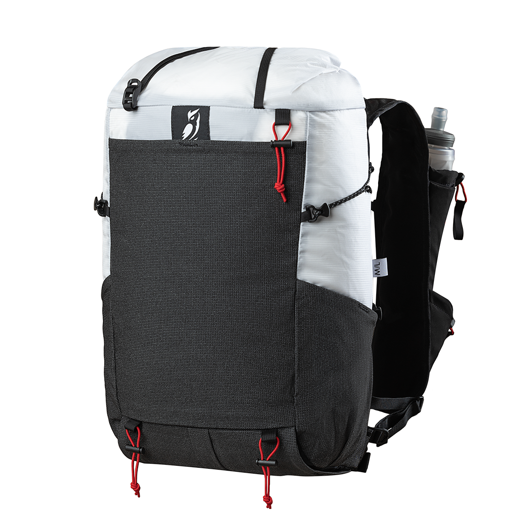 Front side view of the Outdoor Vitals Skyline 30 Fastpack highlighting the expandable front stretch-mesh pocket, side mesh pocket, top roll-closure straps, and running vest harness equipped with a water flask pocket.