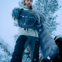 front view of man pulling sleeping bag out near his tent