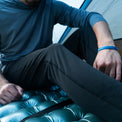 A hiker sitting inside a tent on a sleeping pad, wearing Outdoor Vitals Highline Thermal Leggings and Altitude Sun Hoodie.