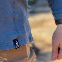 Close-up of the hem and woven brand tag on Outdoor Vitals Tern Ultralight Merino Wool Tee.