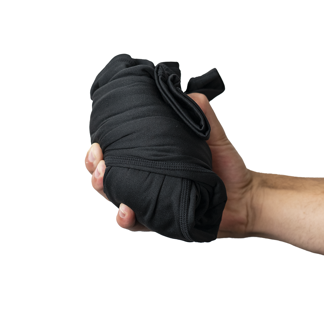 Hand holding a compact, rolled pair of Outdoor Vitals Highline Thermal Leggings.