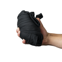 Hand holding a compact, rolled pair of Outdoor Vitals Highline Thermal Leggings.