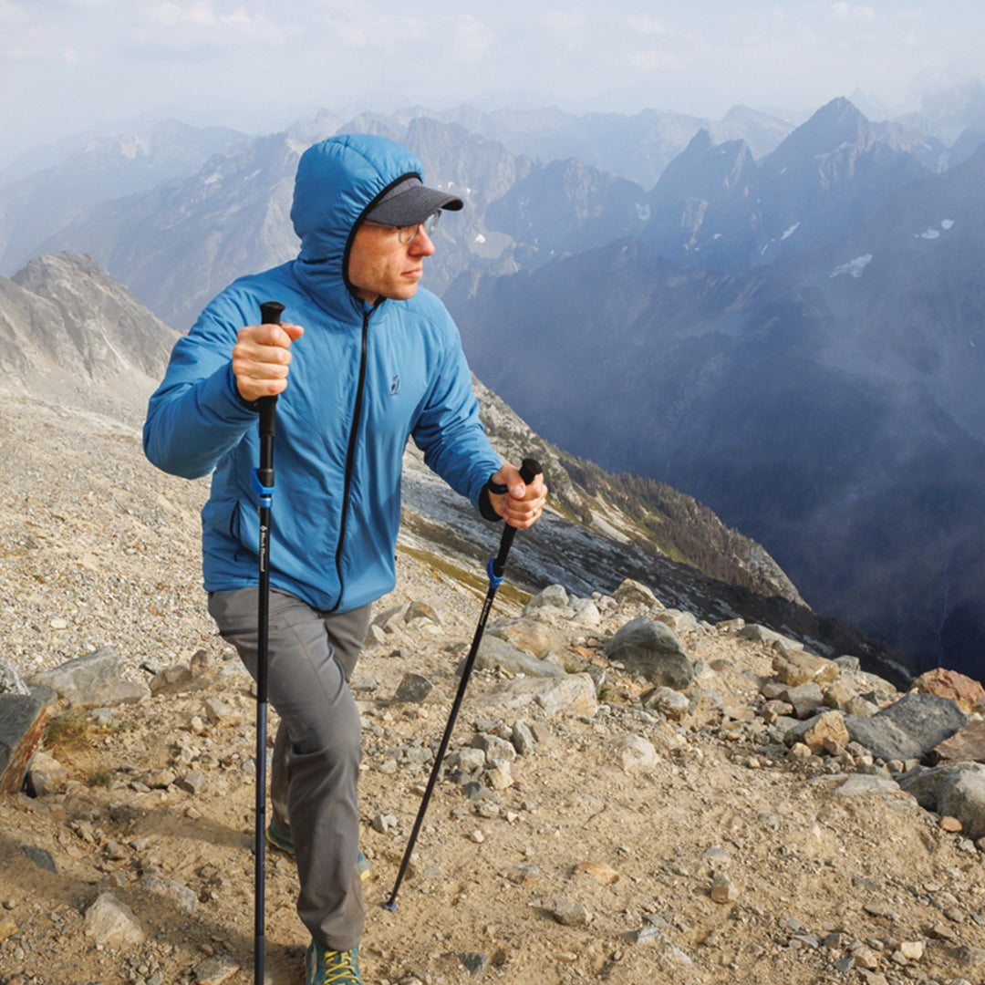 Hiker wearing the Outdoor Vitals Vario Jacket hiking across a rocky mountain summit