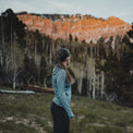 Woman wearing ultralight sun hoodie looking on the mountain