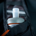 Close-up view of a soft flask nozzle sitting securely inside the shoulder strap pocket of the Outdoor Vitals Skyline 30 Fastpack, featuring an elastic cinch cord to prevent bouncing.