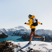 Trail runner wearing the Outdoor Vitals Skyline 30 Fastpack across a snowy ridge.