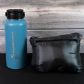 Packed NovaUL jacket beside a water bottle for size comparison