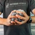 Man compressing a rain jacket into a tight ball to show packability.