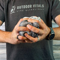 Man compressing a rain jacket into a tight ball to show packability.