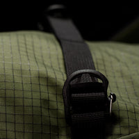 Close-up of a textured bag with a black strap and buckle.