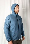 Man wearing the Outdoor Vitals Vario Jacket with the hood up, front angled view