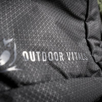 Extreme close-up of the Outdoor Vitals logo and brand name printed on the durable grid-patterned ripstop fabric of the KotaUL Ultralight Travel & Adventure Backpack.