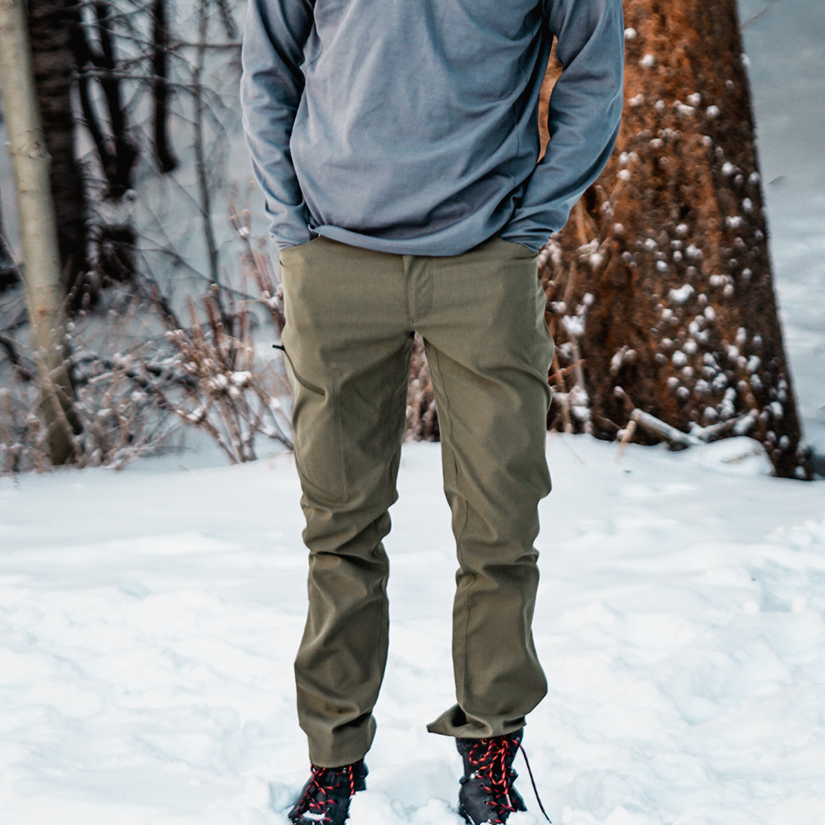 front view of man wearing green hiking pants in the snow