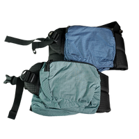 Product shot showing the detachable hip belt pockets of the Outdoor Vitals Shadowlight Carbon 60 Backpack, featuring durable ripstop grid fabric and zippered closures.