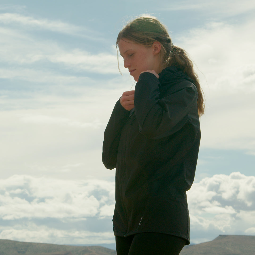 Woman wearing Nebo Windbreaker outdoors under cloudy sky