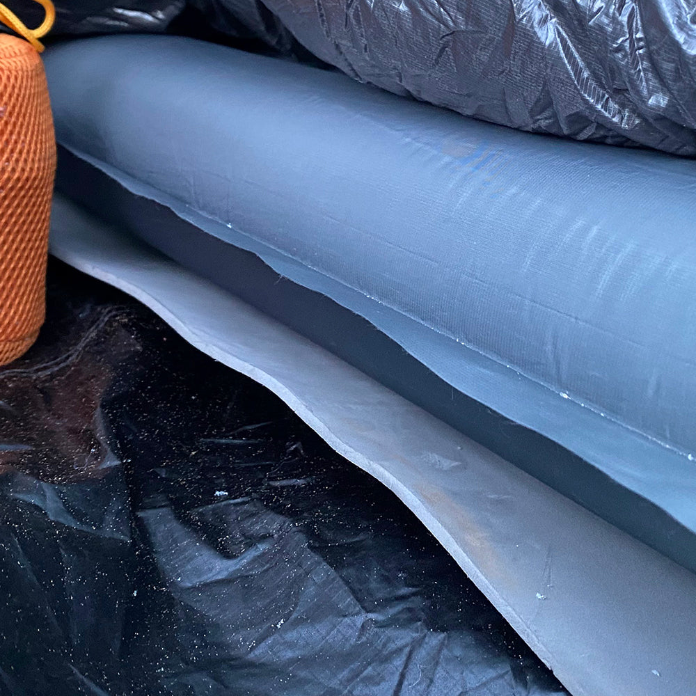 close side view of closed cell foam pad beneath inflatable sleeping pad in tent