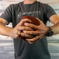 Man compressing a jacket into a tight ball to show packability.