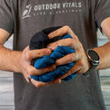 Man compressing a jacket into a tight ball to show packability.