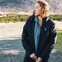 Woman wearing the Women's Outdoor Vitals Vario Jacket in a mountain landscape